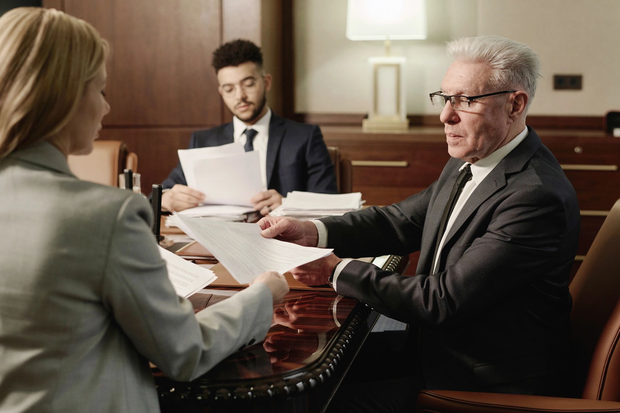 Professionals reviewing documents in a boardroom